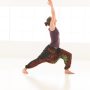 side view of single  women in yoga pose, dressed colorful on window background, face obscured